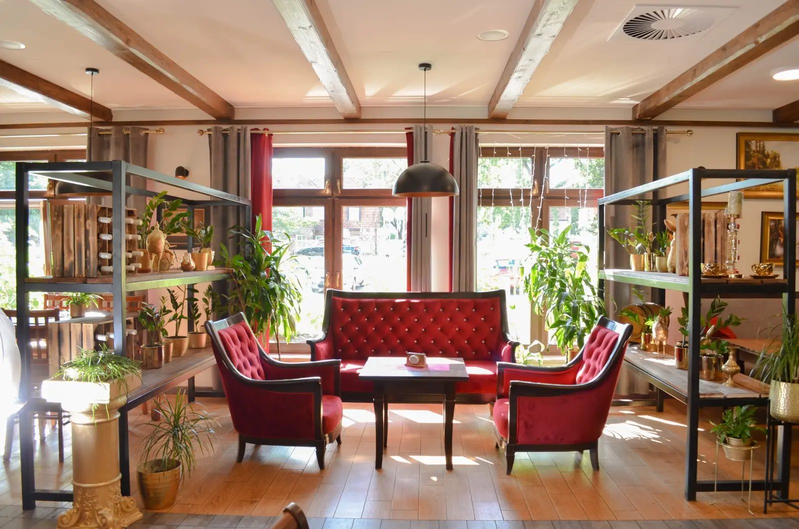 Czerwona sofa i fotele w jasnym wnętrzu Restauracji U Jakuba